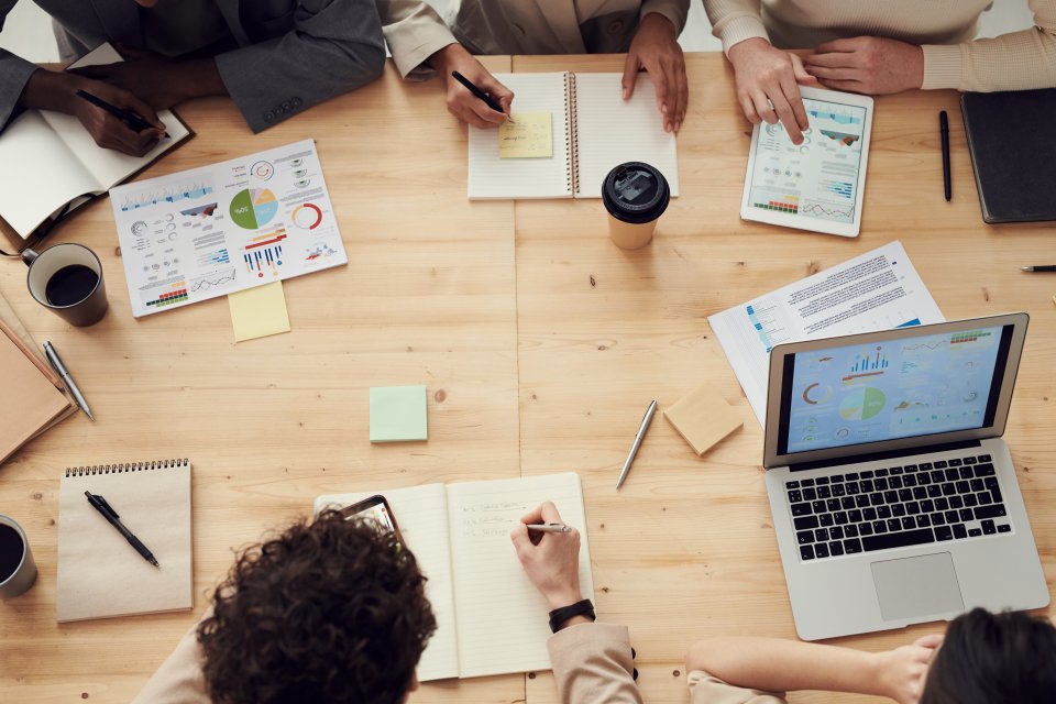 Top down view of a table surrounded by people with paperwork collaborating